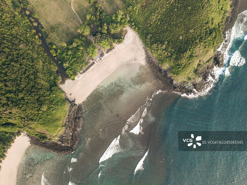 印度尼西亚龙目岛塞梅蒂的航拍图，俯瞰着郁郁葱葱的绿色海岸线、沙滩和湛蓝的海浪。图片素材