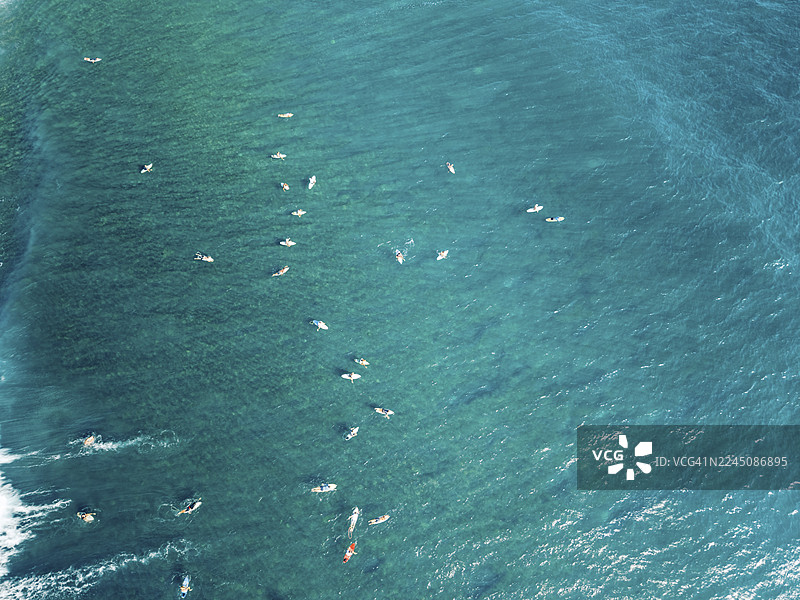 从上方俯瞰，冲浪者们散落在绿松石色的海浪上。印度尼西亚，西努沙登加拉，龙目岛中部，普拉亚巴拉特，色隆贝拉纳克，Mboizz海滩图片素材