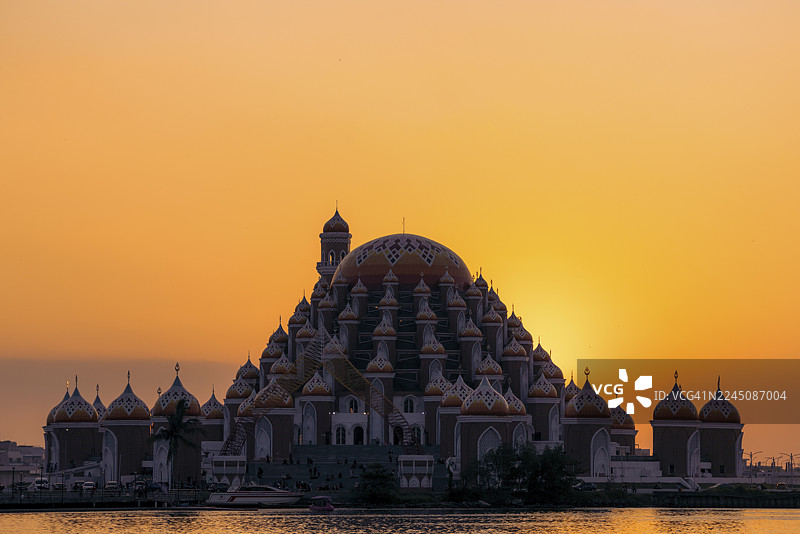 夕阳映衬下，宏伟的清真寺在宁静的滨水区落下帷幕，其精美的穹顶令人惊叹。地点：印度尼西亚，苏拉威西，望加锡图片素材