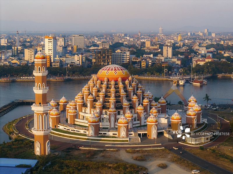 从空中俯瞰一座设计精美的清真寺，拥有众多圆顶，背景是城市天际线。99圆顶清真寺，望加锡，南苏拉威西，印度尼西亚图片素材