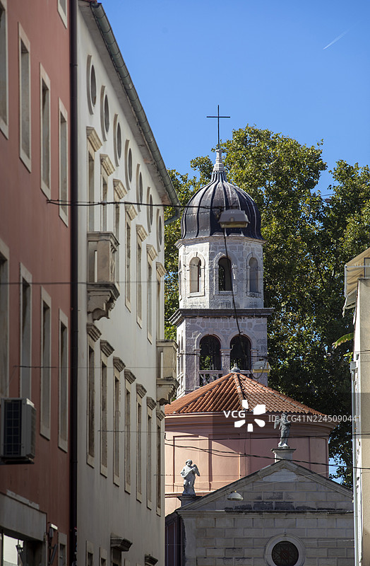 从狭窄视角拍摄的历史建筑，教堂塔楼映衬在蓝天之下。克罗地亚，扎达尔图片素材