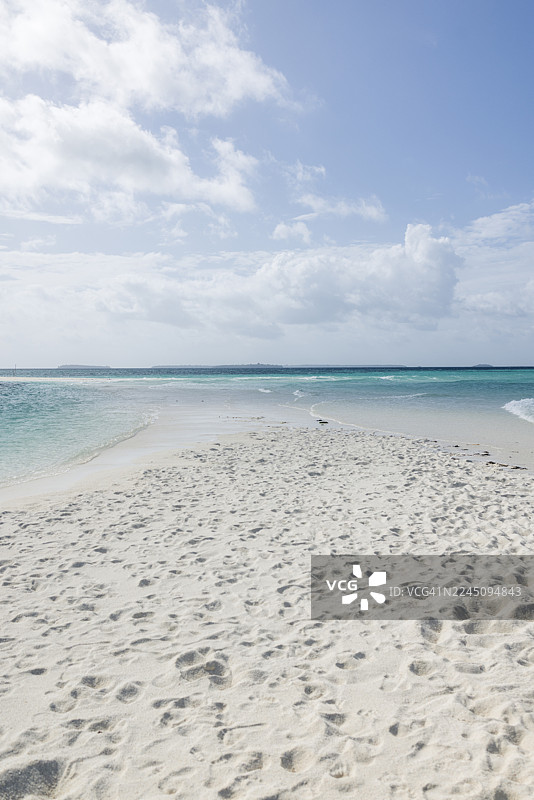 印度尼西亚东南马鲁古凯伊凯奇尔的恩格布洛特海滩，一片洁白沙滩延伸至绿松石色的海洋，天空晴朗，有几朵云彩。图片素材