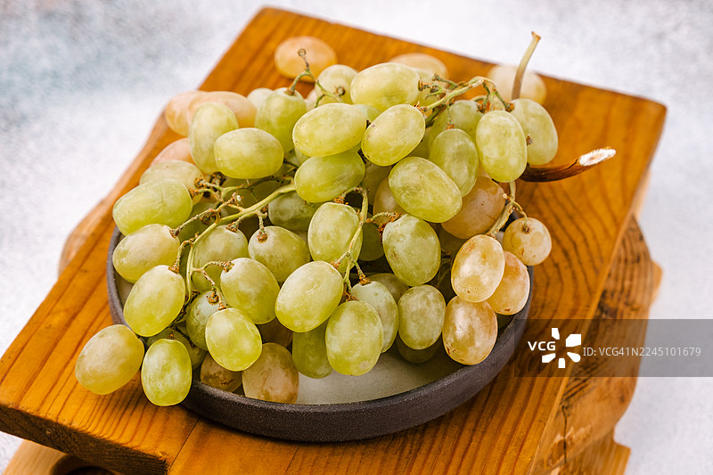 一串白葡萄放在桌上，特写。图片素材