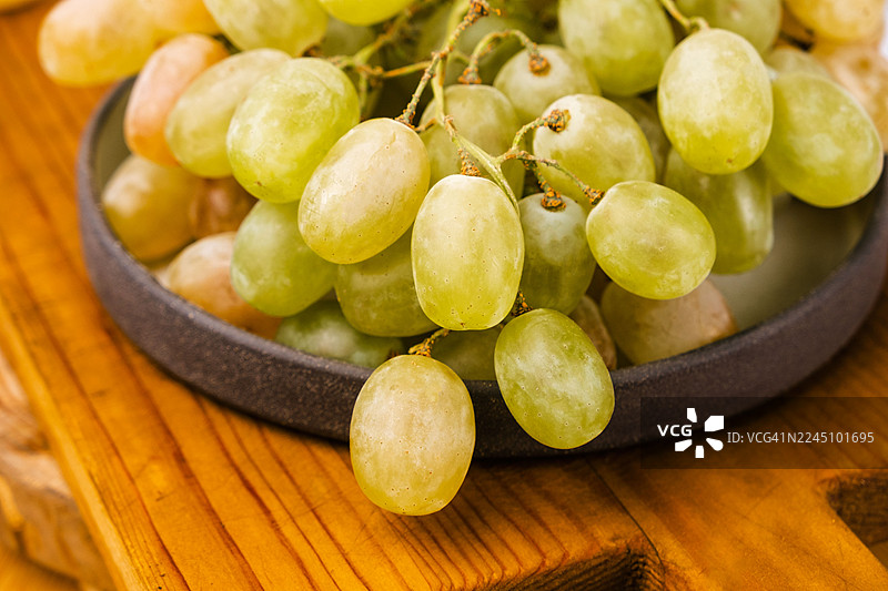 一串白葡萄放在桌子上，特写。图片素材