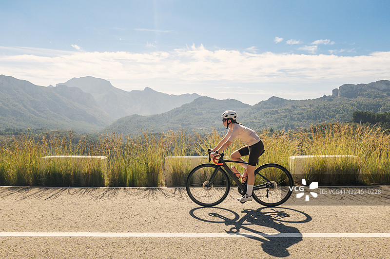 年轻的十几岁的女孩骑车上坡，这里是西班牙哈隆/沙洛谷一条受欢迎的山路——科尔德拉特斯图片素材