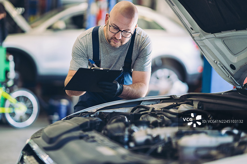 汽车工程师正在检查汽车发动机图片素材