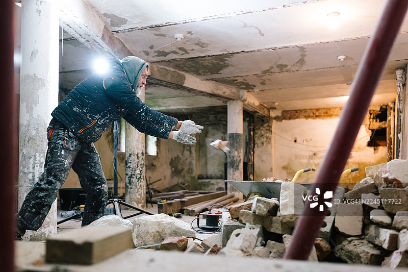 建筑工人将砖头扔进手推车图片素材