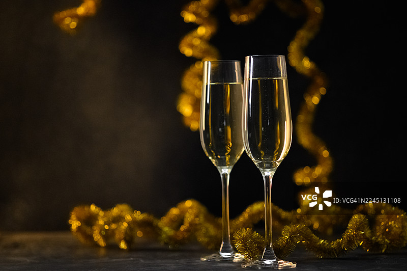 深色节日背景上带有金色花环的优雅香槟祝酒图片素材