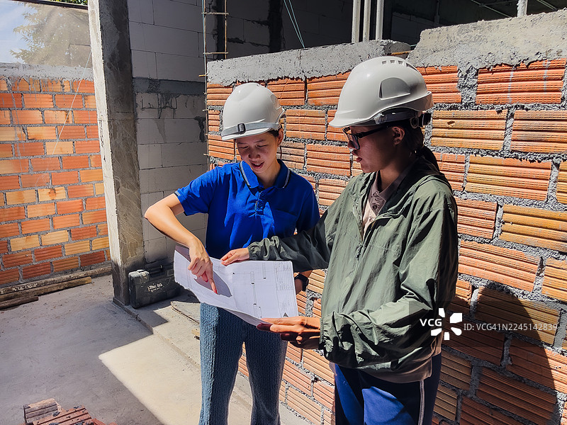 女工程师在现场审阅建筑图纸图片素材