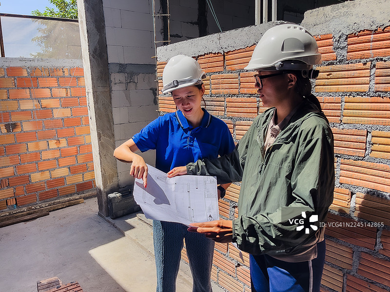 女工程师在工地审阅建筑图纸图片素材