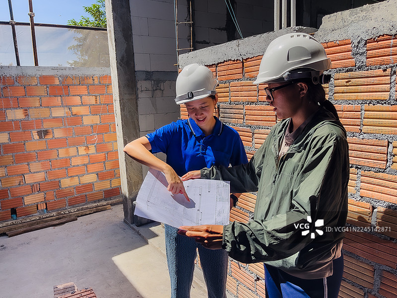 女工程师在施工现场审阅建筑图纸图片素材