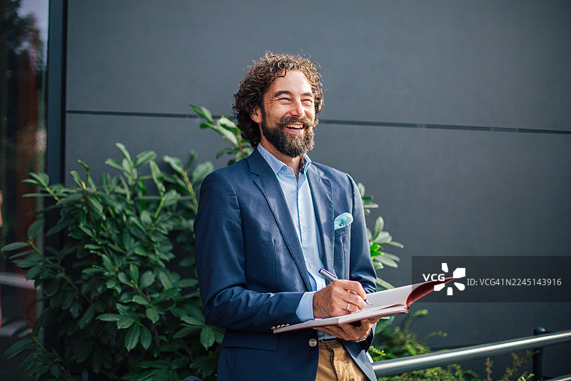 商务人士在户外愉快地记录客户笔记图片素材