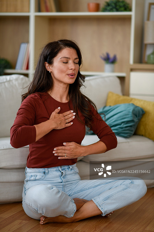 一位女士在家中做呼吸练习图片素材