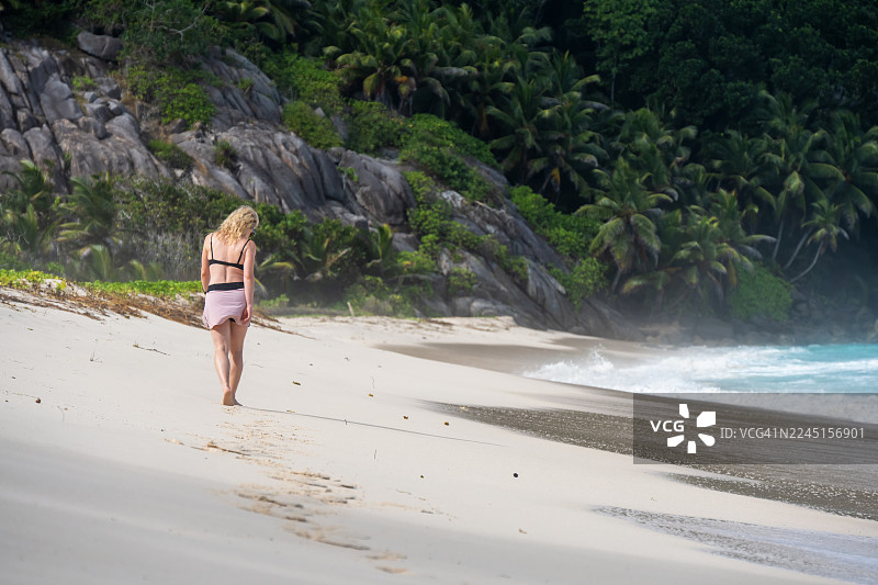 一名女游客正在塞舌尔共和国马埃岛的警察湾散步。警察湾位于马埃岛南部。图片素材