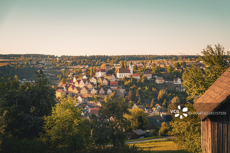 德国卡尔夫区阿尔滕施泰格的晚间山村景象，中心为教堂，周围环绕着众多房屋和树木图片素材