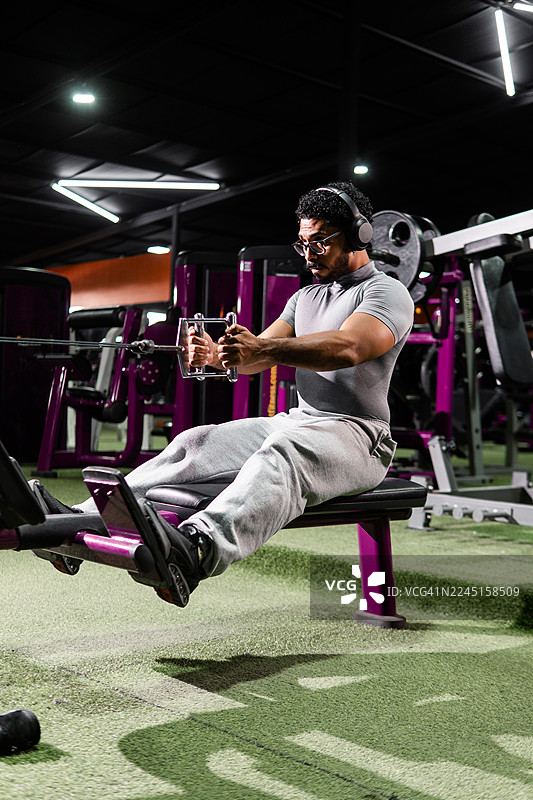 年轻男子在健身房举重锻炼以增强力量图片素材