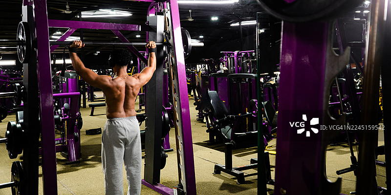 肌肉发达的男性在健身房举重训练图片素材