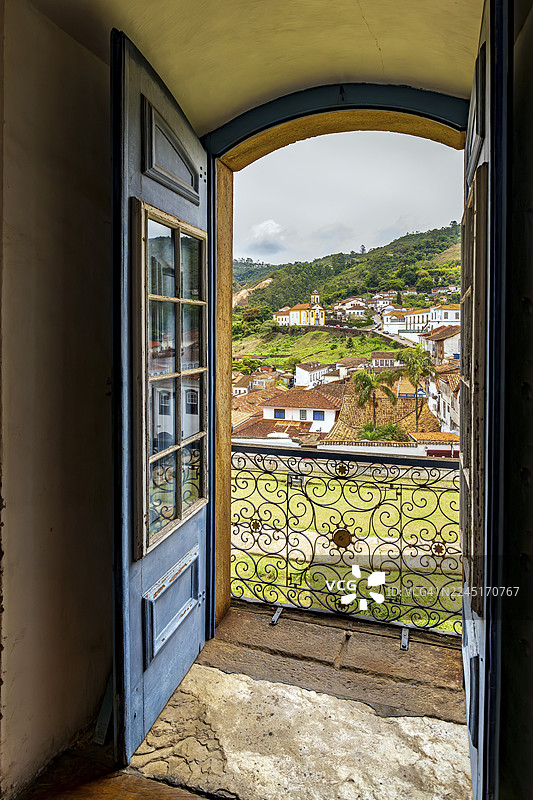巴西米纳斯吉拉斯州欧鲁普雷图市一座历史悠久的巴洛克教堂门框望出去的欧鲁普雷图市图片素材