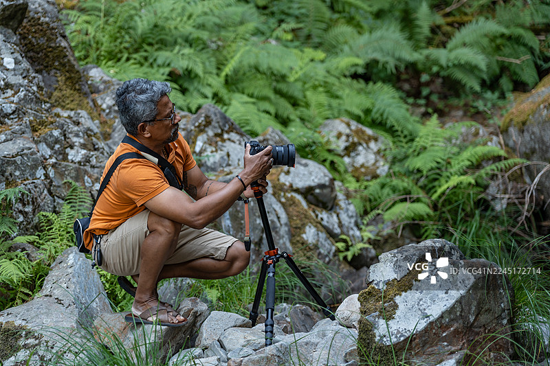 摄影师在森林的岩石上图片素材