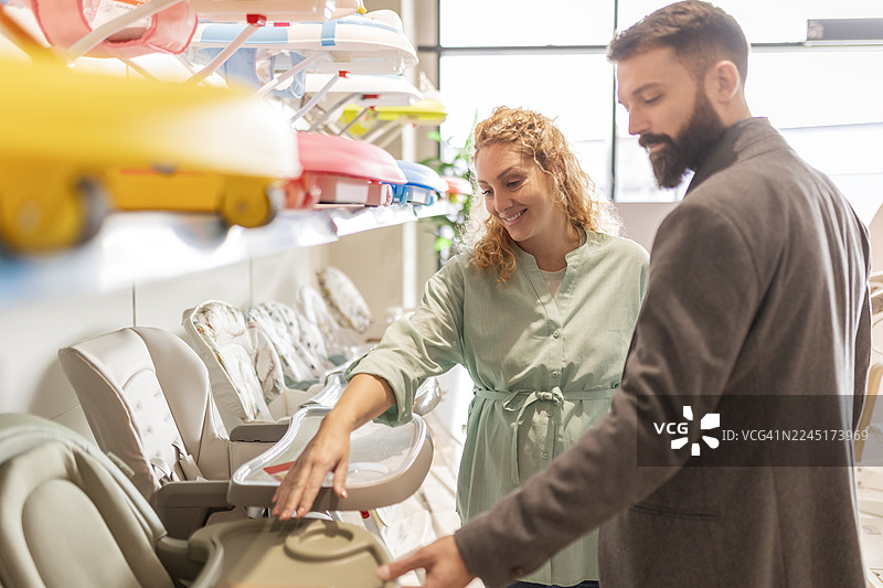 准父母在商店展厅选购婴儿用品图片素材