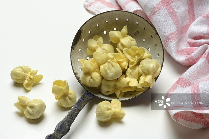 意大利面食“Saccottini”盛放在漏勺中，来自意大利的面食图片素材