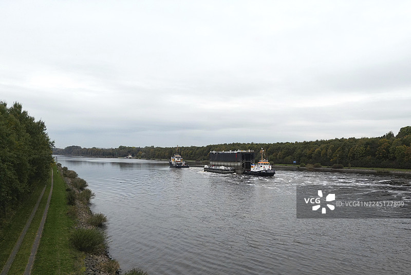 拖船在基尔运河上运送船闸，北欧，基尔运河，基尔运河，石勒苏益格-荷尔斯泰因，德国图片素材