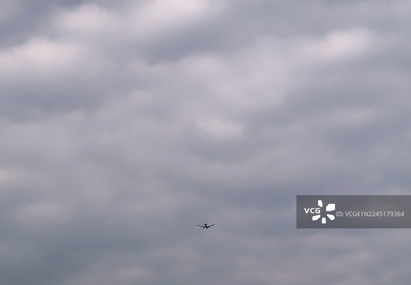 一架双引擎客机在多云的天空中飞行图片素材