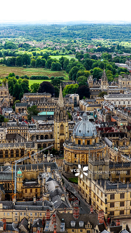 日落时分的牛津大学拉德克利夫大楼和哥特式尖塔的鸟瞰图，包括谢尔登尼安剧院和周边学院的历史性英国建筑，融合了遗产与教育理念图片素材