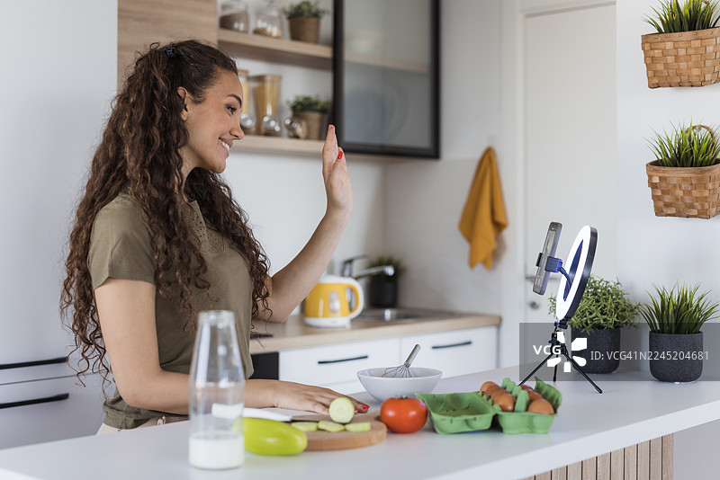 女子在厨房直播分享健康烹饪创意图片素材