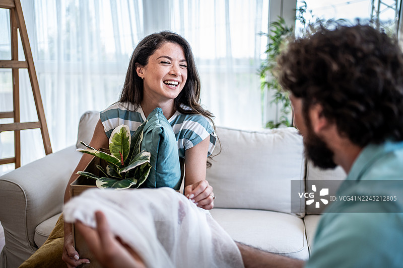 年轻夫妇正在拆箱，搬入新家图片素材