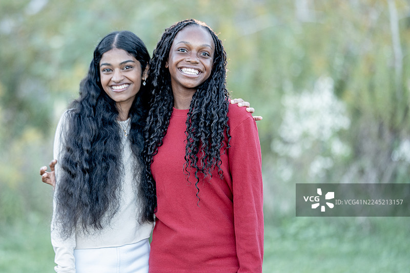 两位黑人女性朋友在户外，面带微笑，拍摄生活方式的休闲肖像照图片素材