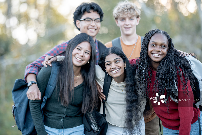 一群多元化的朋友们在户外聚在一起，面带微笑，互相支持，充满青春活力图片素材