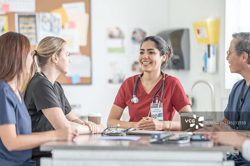 多元化医疗团队在医院开会：女护士带领同事讨论图片素材