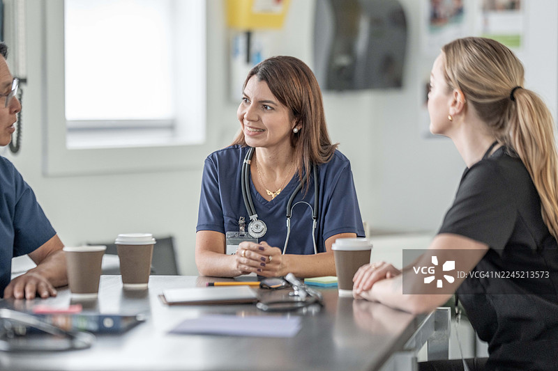 友好的医疗团队在诊所咨询台与医生和患者开会图片素材