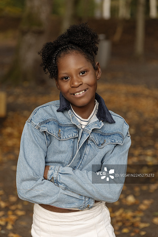 一位漂亮的黑人女孩在公园的秋日散步中玩耍图片素材