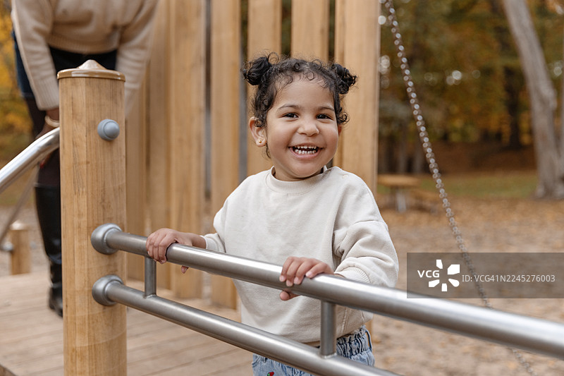 一个漂亮的黑人小女孩在公园的秋日散步时玩耍图片素材