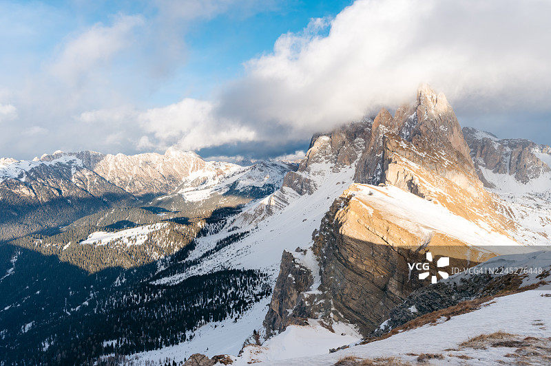 白雪皑皑的白云岩山脉，云层戏剧性地翻滚，山峰沐浴在阳光下。图片素材
