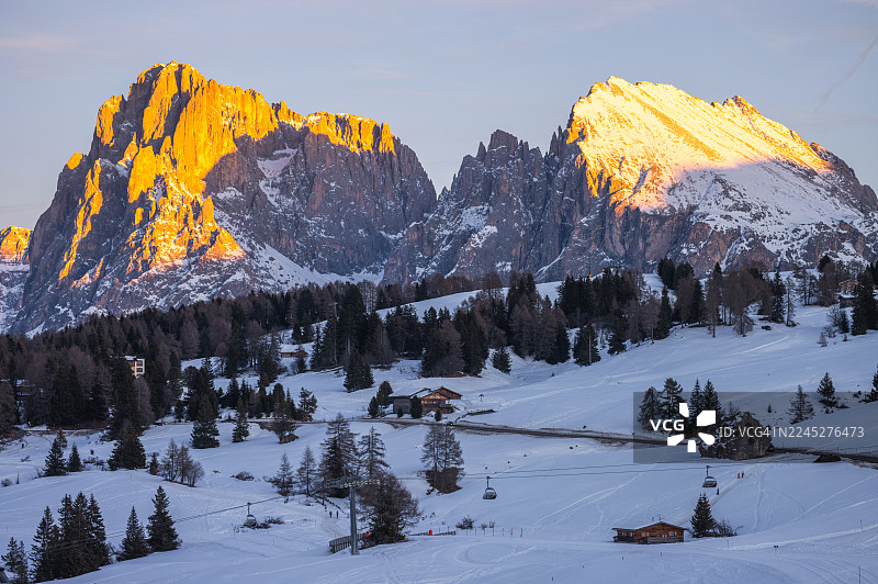 滑雪者在多洛米蒂斯的雪坡上享受金色时光，景色壮丽图片素材