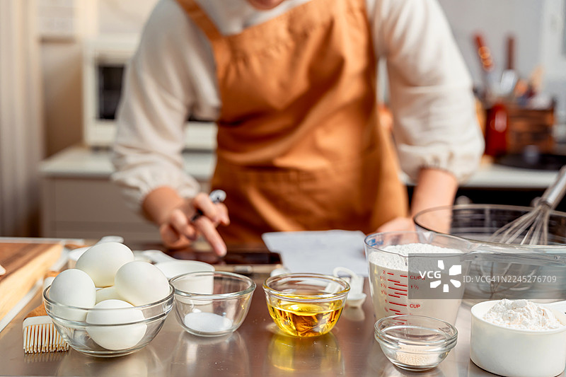 亚洲女性在家里的厨房为节日家庭聚会制作自制披萨。图片素材