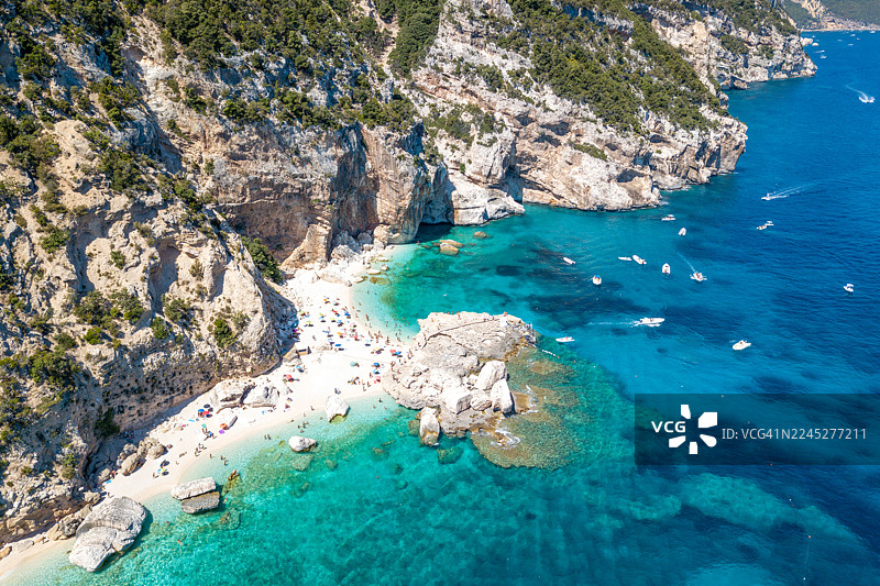 游客们在撒丁岛享受美丽的卡拉马里奥卢海滩和清澈碧绿的海水图片素材