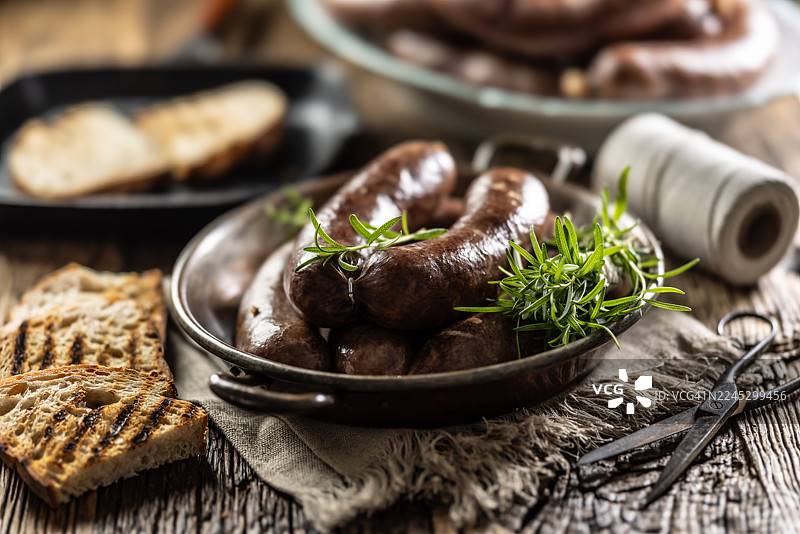 烤香肠配面包和香草。传统欧洲食物，如德式香肠、血肠或捷克香肠。图片素材
