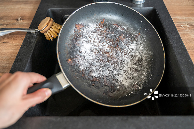 水槽里烧焦的锅和清洁粉图片素材