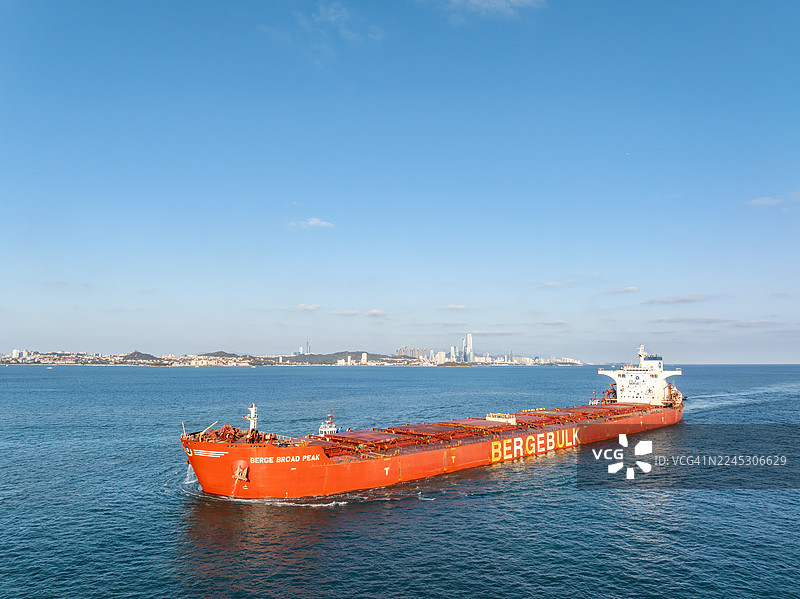 “博格布罗德峰”号散货船航行于青岛城市天际线前的海面上图片素材