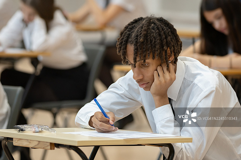 一名男高中生在宽敞的大厅里参加考试图片素材