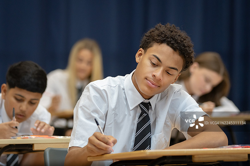 自信的高中生在宽敞的大厅里参加考试图片素材