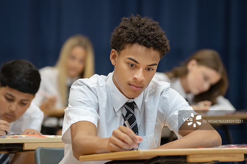 自信的高中生在宽敞的大厅里参加考试图片素材