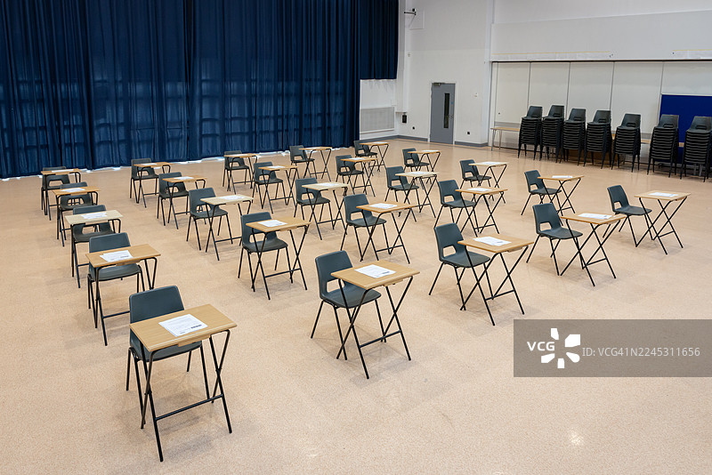 摆满课桌的学校大厅，为学生和考试做好准备图片素材