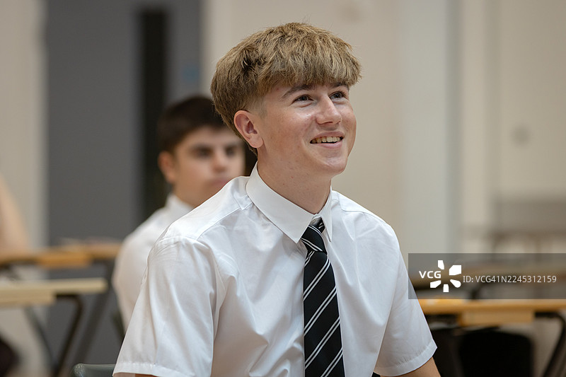 快乐的高中生在宽敞的考场里参加考试图片素材