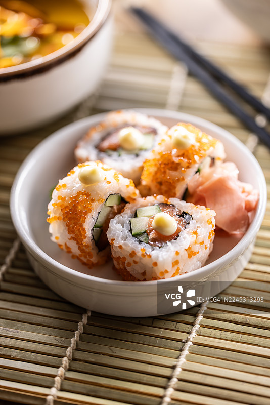 一碗加州卷，外层裹着亮橙色的飞鱼籽（tobiko），内馅是三文鱼和黄瓜，并点缀着一勺日式蛋黄酱。图片素材