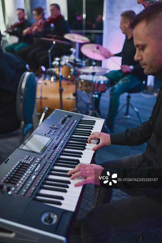 键盘手在舞台上的现场音乐表演，背景是鼓图片素材